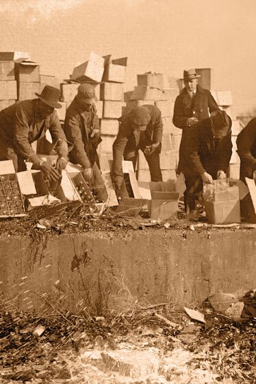 government agents destroying cases of hard liquor and beer during Prohibition