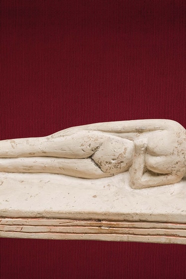 A headrest supports a woman’s head as she sleeps in an 18th dynasty limestone statuette.