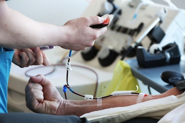 A donor carer begins drawing blood