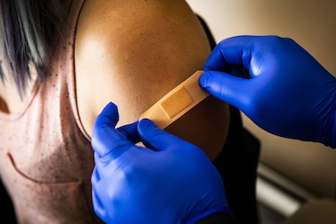 A healthcare worker places a band-aid on a patient after administering a dose of the Covid-19 vaccine in Boston.