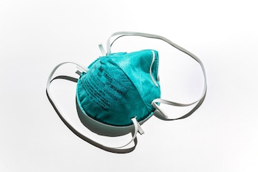 A green N-95 mask on a white background