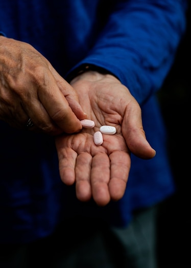 A patient holds out pills of Paxlovid in her hand.