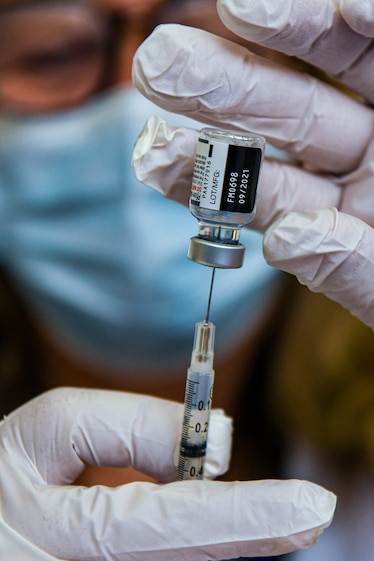 A close-up view as a pharmacist extracts a COVID-19 booster vaccination from a vial.